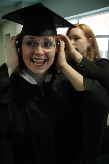 As the excitement builds, Sociology Graduate Kathleen Murray readies herself to graduate with the assistance of her former roommate Lana Cosby at fall graduation. - Photo by Brad Moore