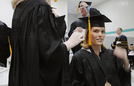 Wendy Bradshaw gets some help with her mortarboard duing fall graduation. - Photo by Kristen Nicole Sayres