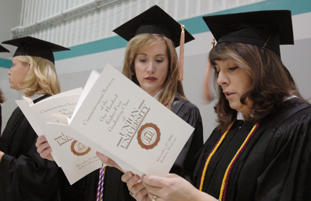 Nursing graduates read over the program at Fall Graduation 2005. - Photo by Kristen Nicole Sayres