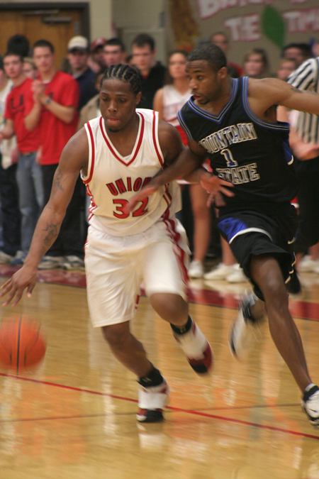 Mack Bealim (32) dribbles down the court as a Mountain State defender guards him.  - Photo by Kyle Kurlick