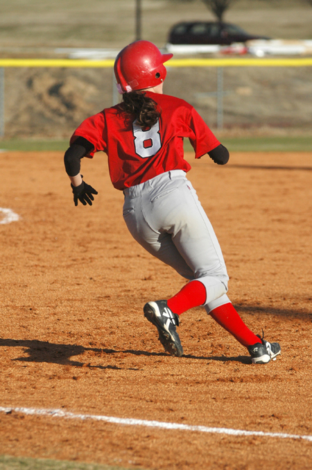 Freshman Michelle Albonetti (8) rounds first base after getting a base hit.   - Photo by Brad Moore