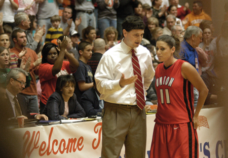 Head Coach Mark Campbell gives guidance to Jennifer Henson on the sidelines during the NAIA Women's Basketball National Championship Game.  - Photo by Jim Veneman