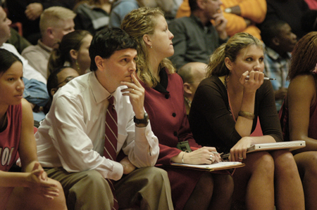 Head Coach Mark Campbell, Assistant Coach Katie Woodruff, and Graduate Assistant Molly York sit through the final minutes of the NAIA Women's Basketball National Championship Game. - Photo by Jim Veneman