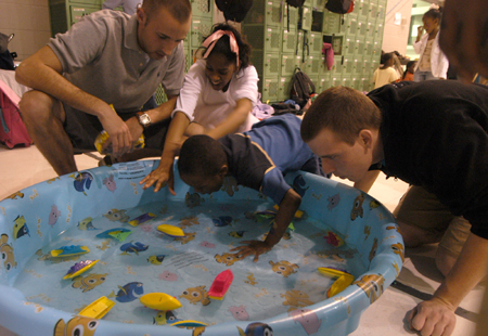 Jason Polk and Jonathon Russnoggle run a game in a swimming pool at the Jackson Boys & Girls Club during The Spring Fling. The Spring Fling was an activity where the Club and SASW collaborated to make a day of excitement for at-risk kids while giving student social workers experience. - Photo by Heather Phillips