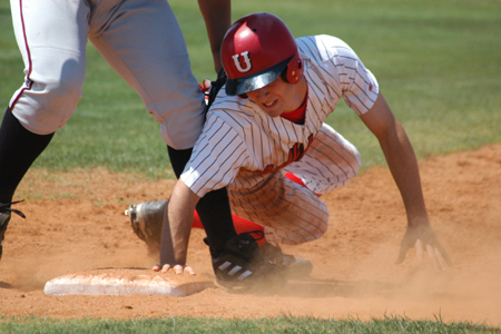 Junior outfielder Tyler Porter dives back into first base safely, but not before getting a hard tag in the ribs. - Photo by Steven Aldridge