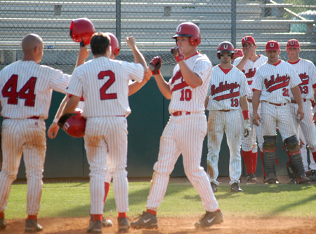 Sophomore Judson Powers (10) gets congratulated at home plate following a homerun.  Jeffery Jackson (2) and Zach Lowery (44) scored on the homerun. - Photo by Steven Aldridge