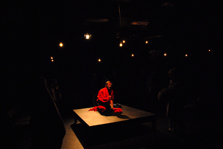 Jared New' J.B. is surrounded by the rest of the cast near the end of the theatre's production of <em>J.B.</em> - Photo by Morris Abernathy