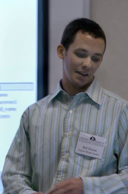 Senior Bill Dixon, digital media studies major, explains the process he went through to create his portfolio website during the Scholarship Symposium. - Photo by Heather Phillips