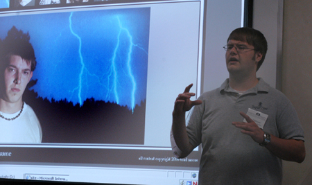 Senior Brad Moore, digital media studies major, explains the intricacies of his personal portfolio website during the Scholarship Symposium. - Photo by Heather Phillips
