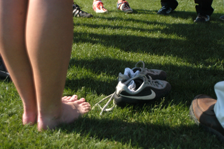 A few of the women soccer players take off their shoes after a hard practice before they gather in a circle to pray.  - Photo by Heather Phillips