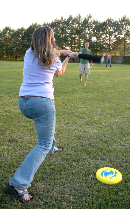 Heather Phillips (batting) takes a swing at Landon Preston's pitch during a baseball game with classmates at President Dockery's house during Happy Trails, a farewell event for graduating seniors sponsored by Young Alums. - Photo by Brad Moore