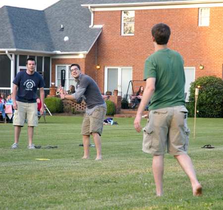Sam Bullington waits on the pitch from Landon Preston as Jared Lawrence watches at President Dockery's house during Happy Trails, a farewell event for graduating seniors sponsored by Young Alums. - Photo by Brad Moore