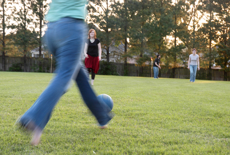 Stephanie Jones runs in for the kick while Alice Calvery (middle) and Jill Zimmer (right) anticipate with classmates at President Dockery's house during Happy Trails, a farewell event for graduating seniors sponsored by Young Alums. - Photo by Brad Moore