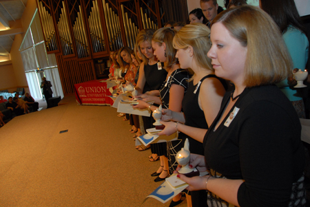 BSN graduates pass the light from lamp to lamp during the lamplighting ceremony. - Photo by Morris Abernathy