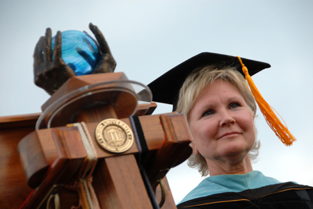 Pam Sutton, English professor and faculty member of the year, stands by the university mace while the graduates filed onto the Great Lawn. - Photo by Morris Abernathy