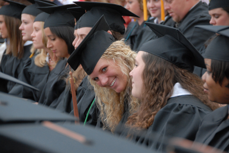 Ashley Abernathy peeks her head around the rest of the graduates to flash her father a smile during spring graduation. - Photo by Morris Abernathy