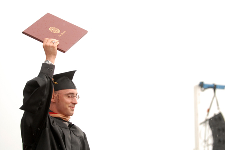 Chris Morris proudly walks across the stage after receiving his MBA diploma during the spring graduation ceremony. - Photo by Kathleen Murray