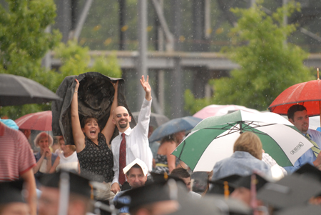 Friends and family stayed during the rain to cheer on their graduates during spring graduation. - Photo by Kathleen Murray