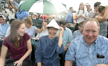 Friends and family stayed during the rain to cheer on their graduates during spring graduation. - Photo by Heather Phillips