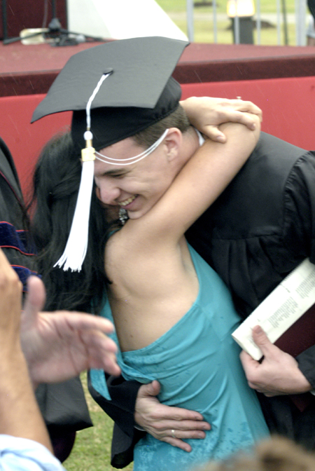 Political science major Josh Dougan, of Gadsden, Tenn., received a big hug after accepting the Elizabeth Tigrett Medal during the spring graduation ceremony. - Photo by Kyle Kurlick