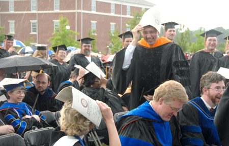 Nursing Professor Mark A. Kossick tries in vain to remain dry at graduation ceremonies on the Great Lawn. - Photo by Tim Weisemann