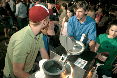 Matthew Diggs waits in line for a snow cone while Luke Pruett prepares the treats for students at the annual Howdy Party. - Photo by Brad Moore