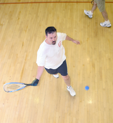 Cam Tracy, web development agent, chases down a ball off the back wall during a racquetball game against Jim Veneman. - Photo by Kyle Kurlick