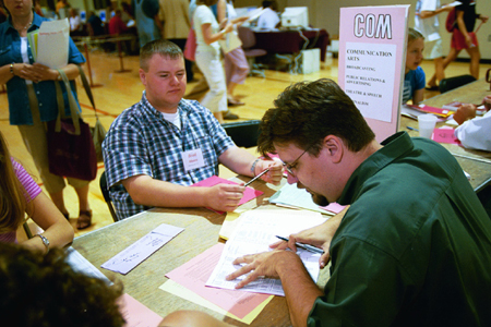 Dr. Chris Blair, assistant professor of Communication Arts, advises freshman Brad Moore during Freshman Pre-Registration in June. - Photo by Jim Veneman