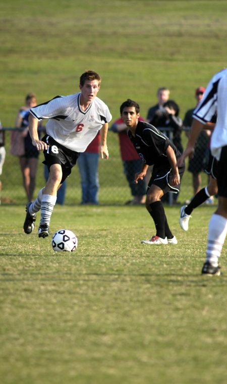 Duncan Nicol (6), junior midfielder, dribbles the ball away from a defender. - Photo by Kathleen Murray