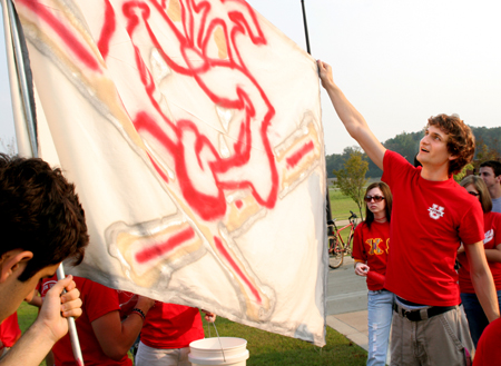 Ronald Long (right) assists with a bulldog flag during a pep rally before a Bulldog soccer match. - Photo by Kyle Kurlick
