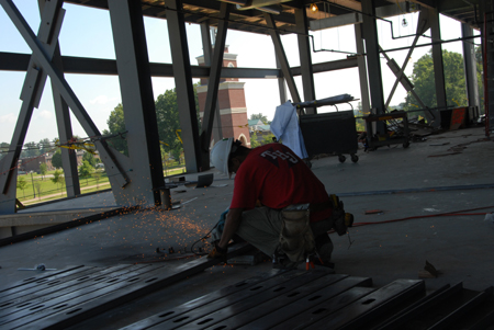 A worker prepares steel wall studs during the construction of White Hall. - Photo by Morris Abernathy