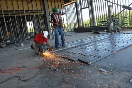 A worker prepares steel wall studs during the construction of White Hall. - Photo by Morris Abernathy