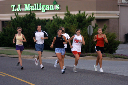 Charley Moss, Head Coach Gary Johnson, Candace Cross, Lydia Bond, Jill Konkol and Rachel Winford of the women's cross country team practice early in the morning just outside of Union's campus. - Photo by Brad Moore