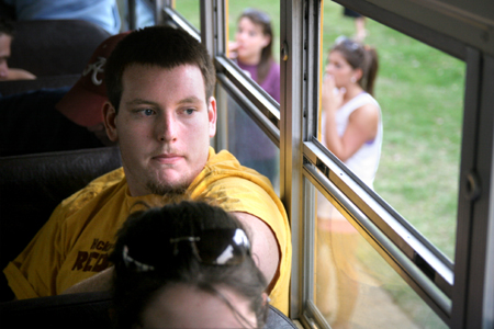John Hall peers out the school bus window during the Young Alum's Road Trip to Nowhere.   The <em>trip</em> was cut short this year due to inclement weather. - Photo by Kyle Kurlick