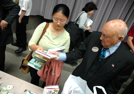 Jasmine Huang purchases autographed copies of Truett Cathy's books after his time with students in Harvey Hall. - Photo by Kristen Nicole Sayres