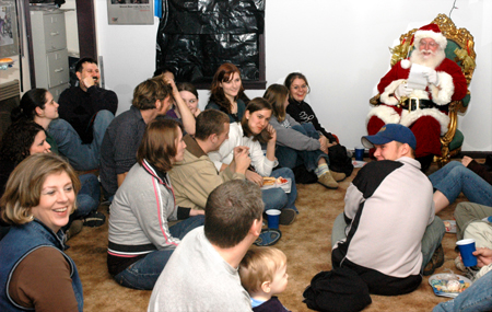 Students, faculty and friends of Union sit in awe and amazement as Santa Claus reads The Night Before Christmas at the annual UAP Photo House Christmas party.
 - Photo by Brad Moore