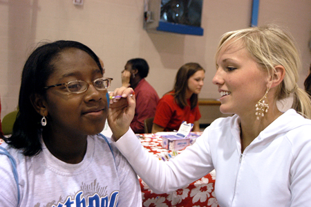 Ashley Cherry paints the face of a young girl at the Boys and Girls Club of Jackson during The Spring Fling.  The Spring Fling was an activity where the Club and SASW collaborated to make a day of excitement for at-risk kids while giving student social workers experience. - Photo by Heather Phillips