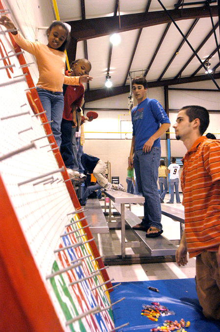John Taylor & Drew Rhodes man a plinko board at the Jackson Boys & Girls Club during The Spring Fling. The Spring Fling was an activity where the Club and SASW collaborated to make a day of excitement for at-risk kids while giving student social workers experience. - Photo by Heather Phillips