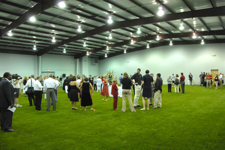 Visitors mingle in the turf room as part of the Fesmire Field House dedication ceremony Aug. 5. The 9,374-square foot room in the Fesmire Field House will allow for the baseball, softball and soccer teams to practice indoors.  - Photo by Morris Abernathy