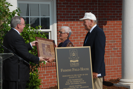 President David S. Dockery presents to Benny and Norma Fesmire a miniature version of the plaque that will be placed on the wall of the Fesmire Field House.  - Photo by Morris Abernathy