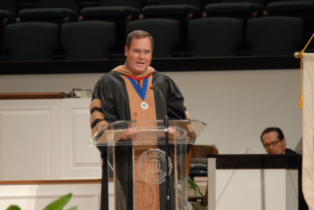 Keith Absher, dean of the McAfee School of Business Administration, reads the names of graduates during summer graduation. - Photo by Morris Abernathy
