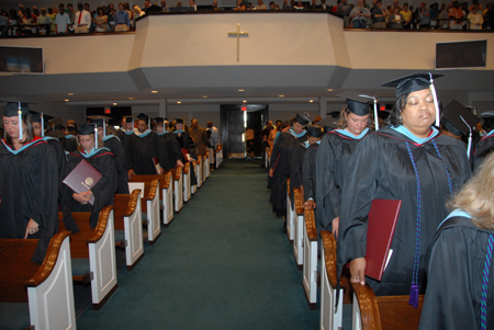 Graduates bowed with degrees in hand during the benediction at summer graduation. - Photo by Morris Abernathy