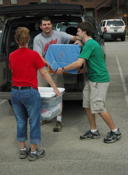 Keith Bates, assistant professor of history, and Bob Sparks help freshmen move in during New Student Orientation. - Photo by Matthew Diggs