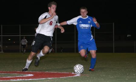 Senior Duncan Nicol goes for a steal against a Lindsey Wilson opponent. - Photo by Stephanie Schroeder