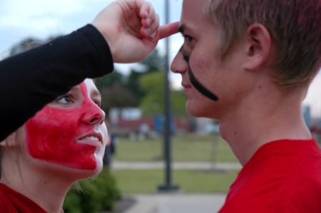 Lydia Marshall paints Benjamin Ferrell's face before the pep rally march from Miller Tower to the soccer fields. - Photo by Kyle Kurlick