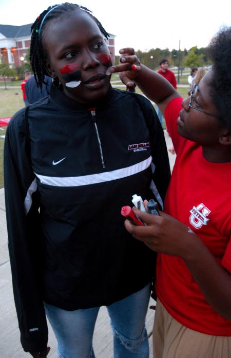 Josephine Owino gets her face painted by Jande Jackson at the Miller Tower pep rally before the soccer game.   - Photo by Kyle Kurlick