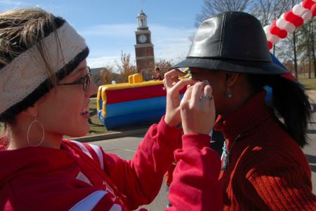 Valerie Trautman gives Renee Jones a temporary Bulldog tatoo at the Arts in the Park event during Homecoming. - Photo by Morris Abernathy