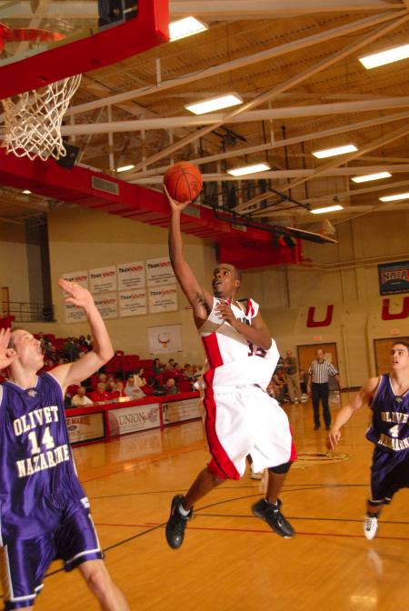 Sophomore guard Tony Brown (white jersey) takes a shot in the Homecoming game versus Olivet Nazarene University (Ill.). - Photo by Morris Abernathy