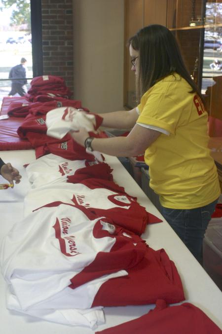 Junior Melanie Harcrow sells Union t-shirts to students and fans during the Homecoming basketball games. - Photo by Stephanie Schroeder