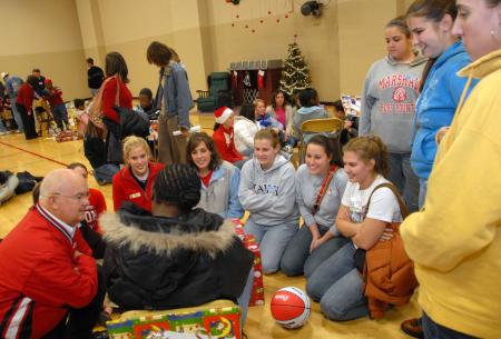 Coach Blackstock and the ladies of the softball team gather around their child at the SAC Carl Perkins' Christmas Party. - Photo by Morris Abernathy